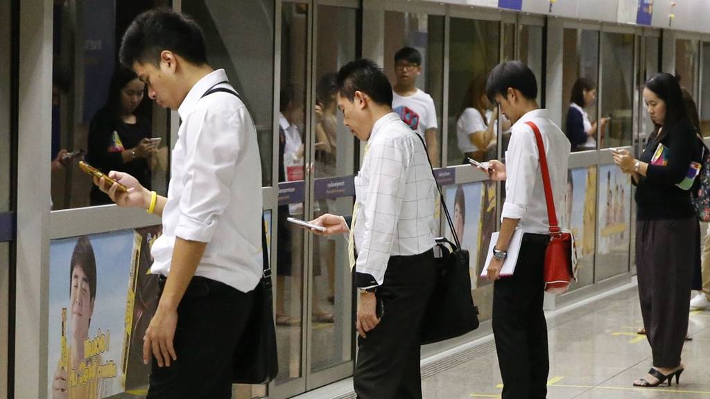 쿼츠 기사에 인용된 전철에서 스마트폰을 보면서 기다리는 사람들