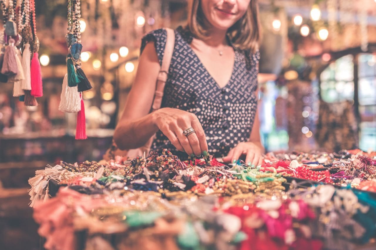 쇼핑 삼매경에 빠진 여성, woman standing beside table of accessories, Image - Artem Bali Featured