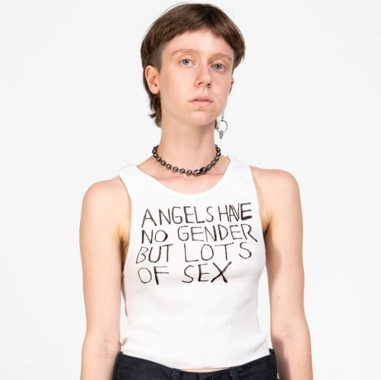 핸드 페인팅된 ​​탱크 탑은 “천사는 성별은 섹스는 많다, Angels have no gender but lots of sex.”는 슬로건을 그려져 있는 탱크 탑