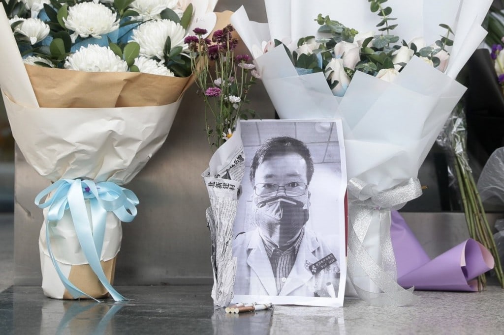 중국의 코로나19에 대한 미온적인 대처를 주장했던 우한 의사 Li Wenliang이 사망 후 우한 중앙병원 앞에 추모 사진과 꽃다발이 놓여져 있다. Photo by EPA-EFE, SCMP