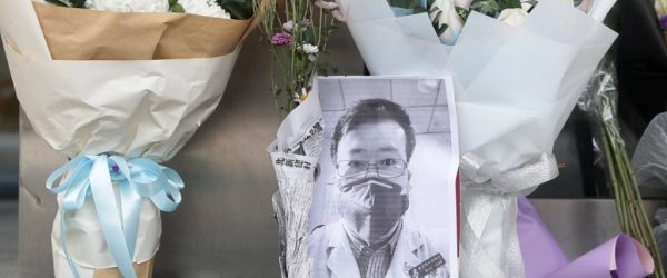 중국의 코로나19에 대한 미온적인 대처를 주장했던 우한 의사 Li Wenliang이 사망 후 우한 중앙병원 앞에 추모 사진과 꽃다발이 놓여져 있다. Photo by EPA-EFE, SCMP